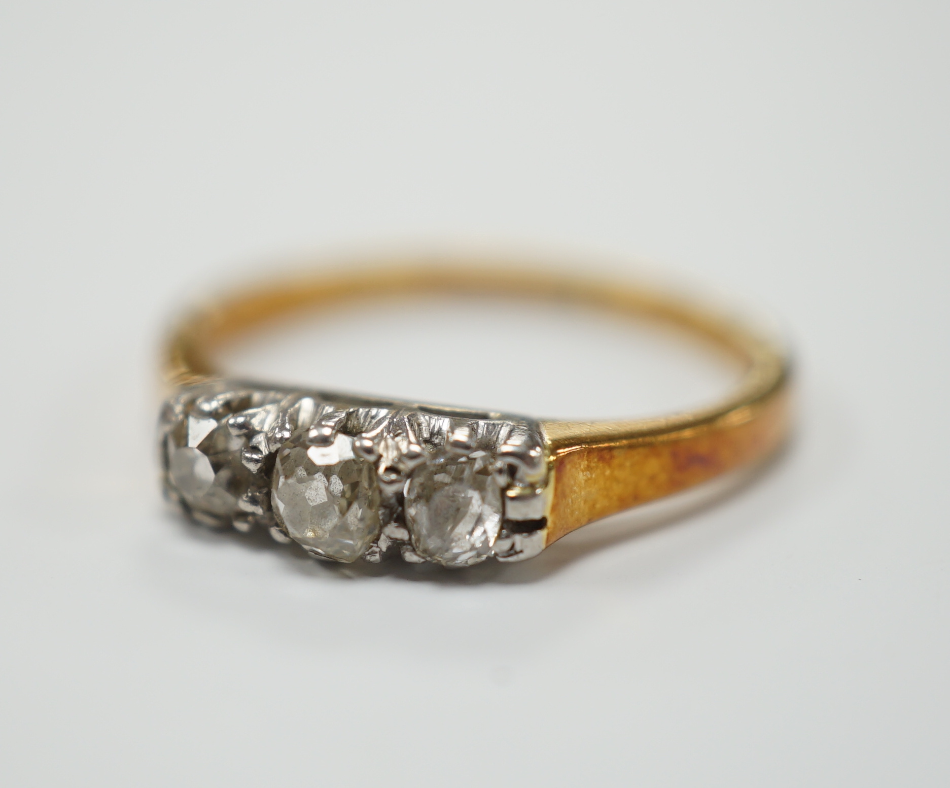 An 18ct, plat. and three stone diamond set ring, size K/L, gross weight 2.5 grams.